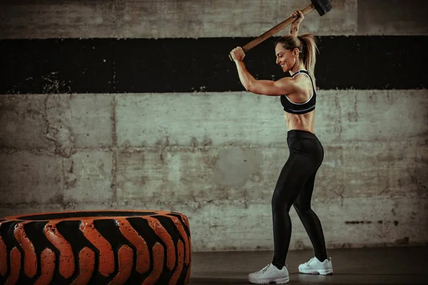 Jovem Mulher Muscular Batendo Pneu Roda Com Martelo Treinamento Ginásio — Fotografia de Stock