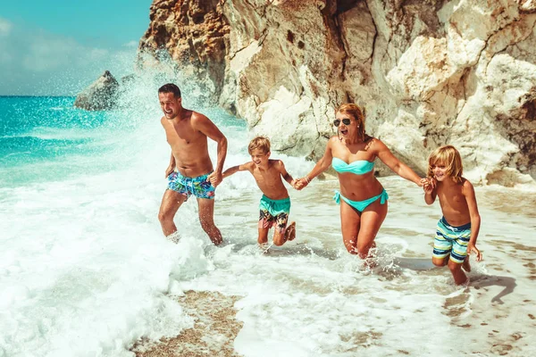 砂浜のビーチで楽しんで小さな子供を持つ若い家族 — ストック写真