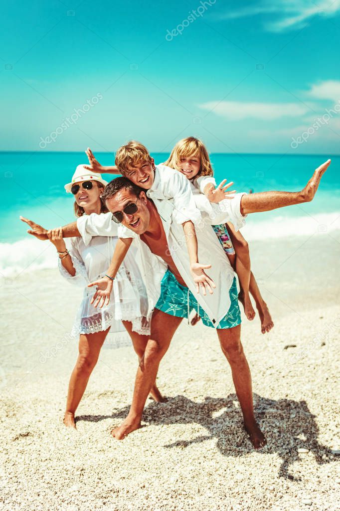 young family with little kids having fun on sandy beach