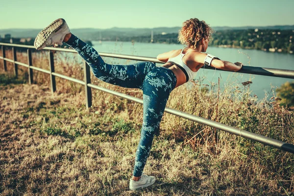 Mujer Deportiva Joven Con Auriculares Haciendo Ejercicio Estiramiento —  Fotos de Stock