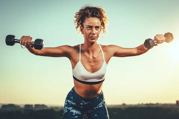 Jovem Mulher Fitness Fazendo Exercícios Com Halteres Fundo Pôr Sol — Fotografia de Stock