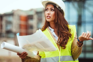 Beyaz kask tutma planları ile genç kadın mühendis