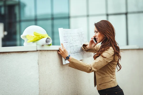 Jonge Ingenieur Vrouw Praten Smartphone Werken Met Blauwdrukken — Stockfoto