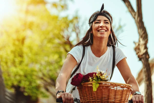 夏の晴れた日の街に沿って自転車に乗る若い女性 — ストック写真