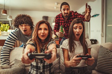 Evde bira ile video oyunları oynarken arkadaşlar heyecanlı