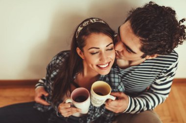 Yeni ev kutuları getirdikten sonra dinlenme ve içme kahve genç çift 