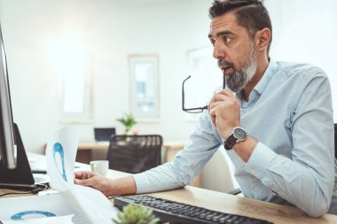 Ofiste bilgisayar başında çalışan olgun işadamı