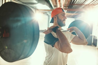 Genç kaslı adam yüksek çekme egzersiz halter ile çapraz eğitim saatinde