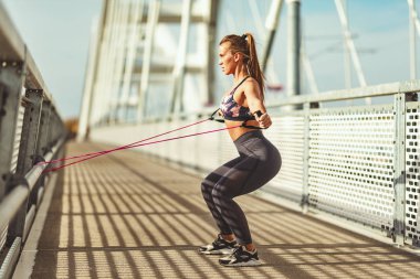 Elastik lastik bant Köprüsü'nde güçlü fit vücut eğitim yaparken kas genç kadın
