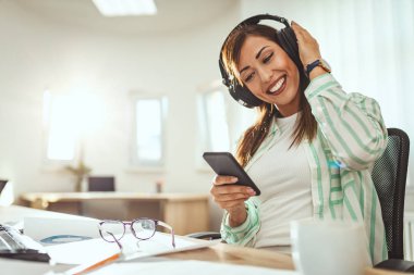 Ofiste çalışan genç gülümseyen başarılı iş kadını