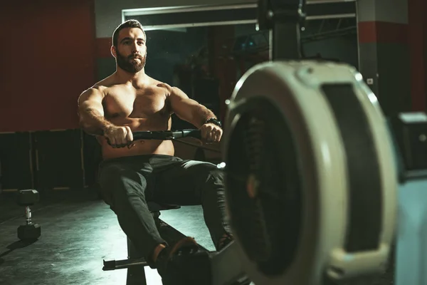 Muscular Hombre Tirando Máquina Remo Gimnasio —  Fotos de Stock