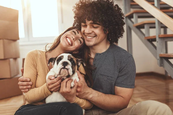 Young Couple Playing Little Bulldog Puppy New Home — Stockfoto