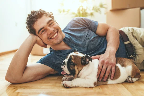 Felice Giovane Uomo Sorridente Con Piccolo Cucciolo Bulldog Nuovo Appartamento — Foto Stock