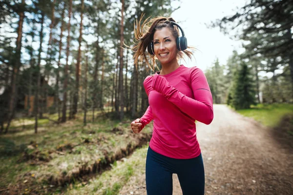 Junge Sportliche Frau Hört Musik Beim Joggen Auf Sonnigem Waldweg — Stockfoto