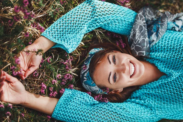 Genç bir kadın güneşli bahar gününde doğada dinleniyor.