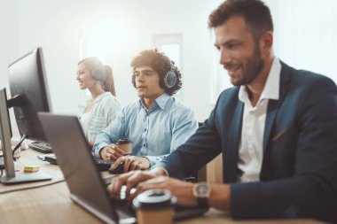 Genç başarılı başlangıç ekibi gündelik ofiste yeni proje üzerinde çalışıyor