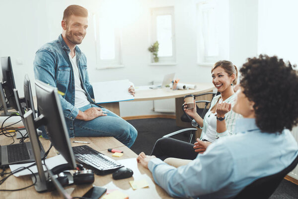 Young freelancers discussing and working on new project in office