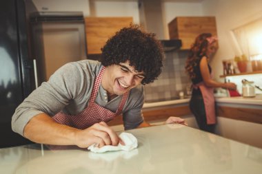 Genç adam mutfakta pişirme sonra tablo Temizleme