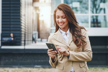 kentsel şehir arka planda Smartphone kullanarak genç başarılı kadın