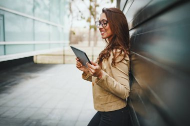 kentsel şehir arka planda genç işkadını tutan tablet