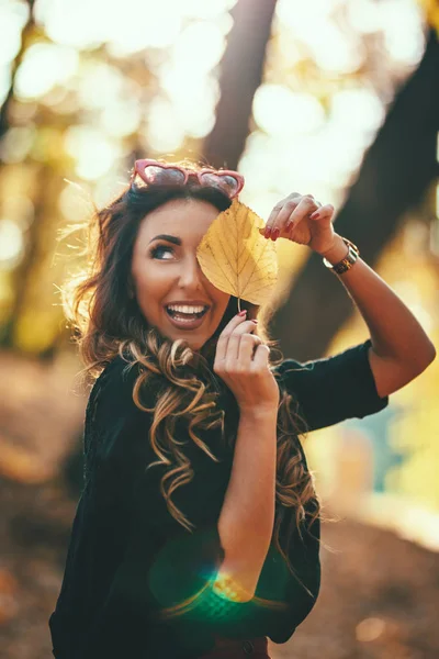 Jonge Vrouw Houden Golden Leaf Camera Kijken — Stockfoto