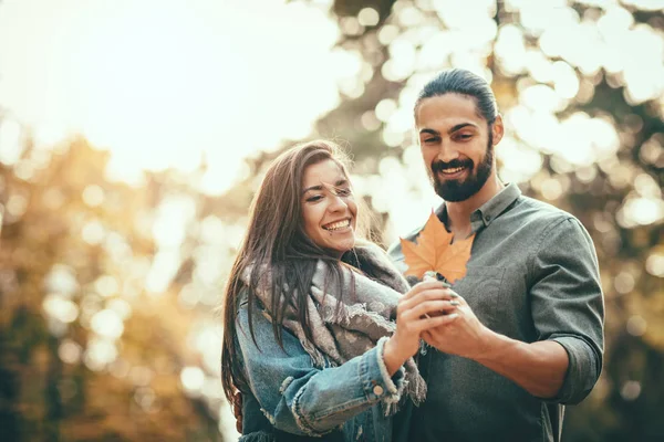Genç çift sonbahar güneşli parkta yürüyüş