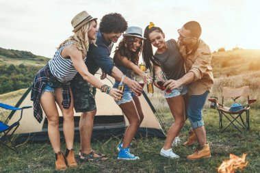 Piknik tabiat manzarası içinde eğleniyor neşeli genç arkadaşlar 