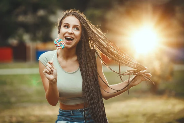 Jovem Alegre Com Longo Cabelo Trançado Afro Lambendo Pirulito Olhando — Fotografia de Stock