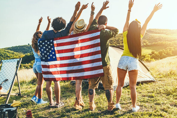 Группа молодых друзей, веселящихся и отдыхающих на пикнике в дикой природе
 