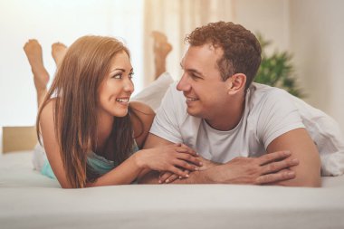 Güzel, genç bir çift birbirlerine sevgiyle bakıyor ve yatakta tembel bir sabah geçiriyorlar..