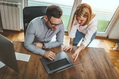 İki genç mühendis meslektaşı ofiste yeni bir proje üzerinde çalışıyor.