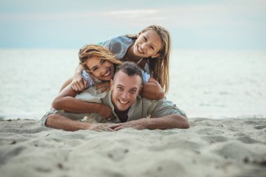 Mutlu aile boş deniz sahillerinde eğleniyor. 