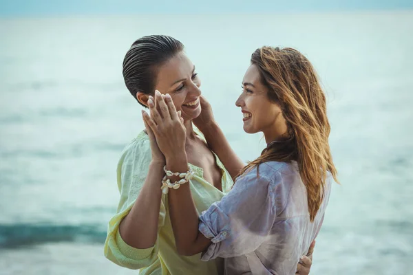 Duas Jovens Mulheres Desfrutando Praia Mar Abraçando Olhando Umas Para — Fotografia de Stock