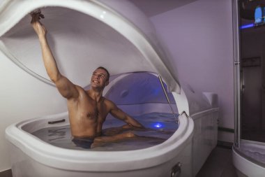 Rahat adam duyusal yoksunluk tankında yüzmeye hazırlanıyor. Sağlık ve Spa konsepti.