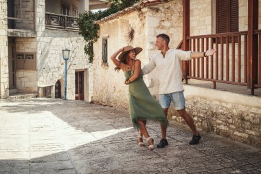 Genç ve güzel bir çift, bir Akdeniz kasabasında yürürken sokakta dans edip eğleniyorlar. Yazın güneşli bir günde birbirlerinin elini tutarak ve gülümseyerek eğlenirler..