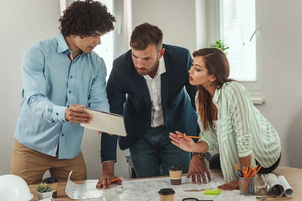 Equipo Tres Jóvenes Arquitectos Está Utilizando Tableta Digital Comunicándose Mientras —  Fotos de Stock