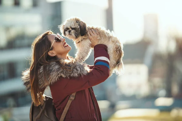 漂亮的年轻时尚女人和她可爱的宠物狗在城里街上玩耍 — 图库照片