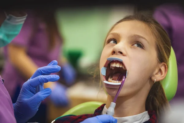 Genç Kız Dişçide Dişçi Koltuğunda Oturur Dişçi Diş Tellerini Takmak — Stok fotoğraf
