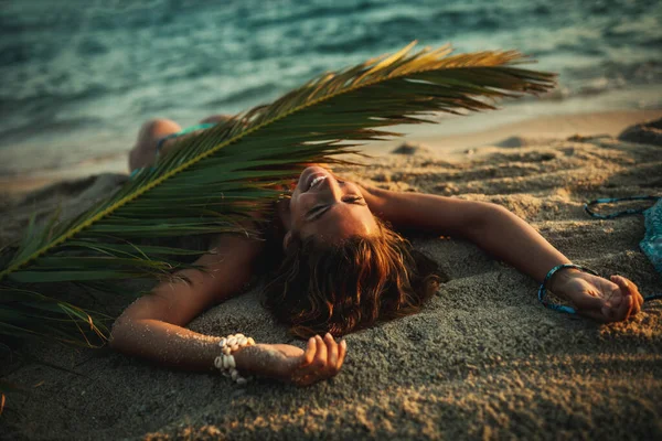 Strzał Atrakcyjnej Młodej Kobiety Leży Tropikalnej Piaszczystej Plaży Pokrytej Liściem — Zdjęcie stockowe