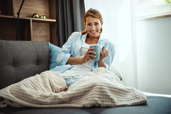 Hermosa Joven Sentada Sofá Disfrutando Una Taza Café Casa Mirando —  Fotos de Stock