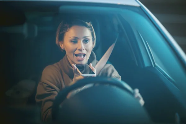 スマートフォンで話している車を運転する素敵な笑顔の若い美しい幸せな女性の肖像画 — ストック写真