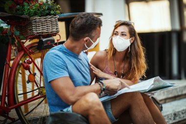 Koruyucu N95 maskeli mutlu bir çiftin Corona 'da tatil yaparken ve bir Akdeniz şehrini keşfederken çekilmesi.. 