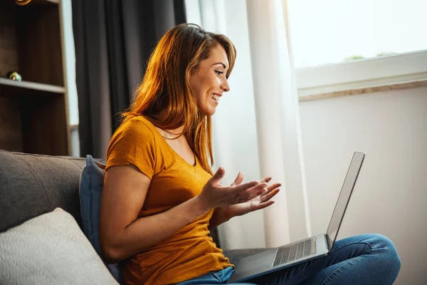 Attraktive Junge Frau Sitzt Schneidersitz Auf Dem Sofa Und Macht — Stockfoto