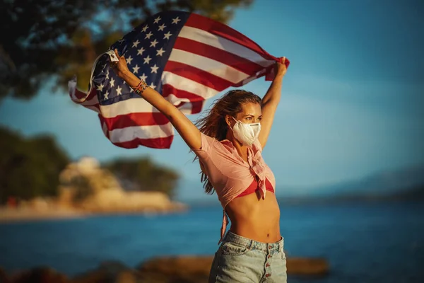 Atractiva Joven Con Bandera Nacional Estadounidense Máscara Protectora N95 Playa — Foto de Stock