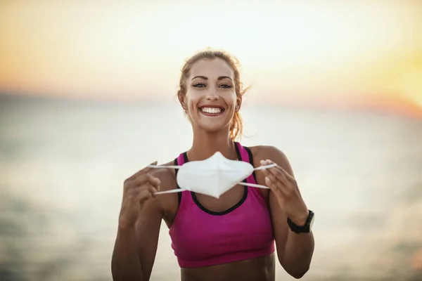 Portret Uśmiechniętej Biegaczki Masce Ochronnej N95 Podczas Treningu Przy Plaży — Zdjęcie stockowe