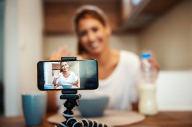 Güzel genç kadın evdeki sağlıklı yiyeceklerle ilgili blog yayınını kaydediyor..