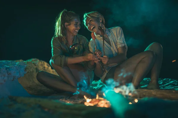 Happy Two Young Smiling Women Sitting Sandy Seashore Fire Evening — Stock Photo, Image