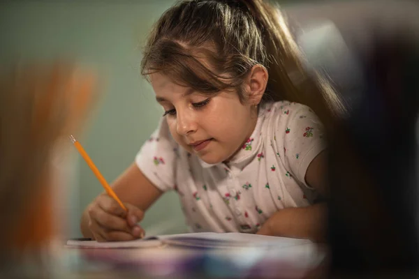 Tiro Uma Menina Diligente Fazendo Uma Tarefa Casa Casa Durante — Fotografia de Stock