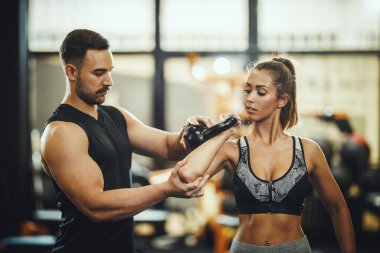 Çekici bir genç kadının spor salonunda kişisel antrenörle çalışması..