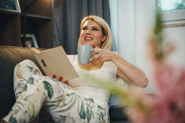 Snímek Roztomilé Mladé Ženy Sedí Pohovce Těší Šálek Kávy Čtení — Stock fotografie